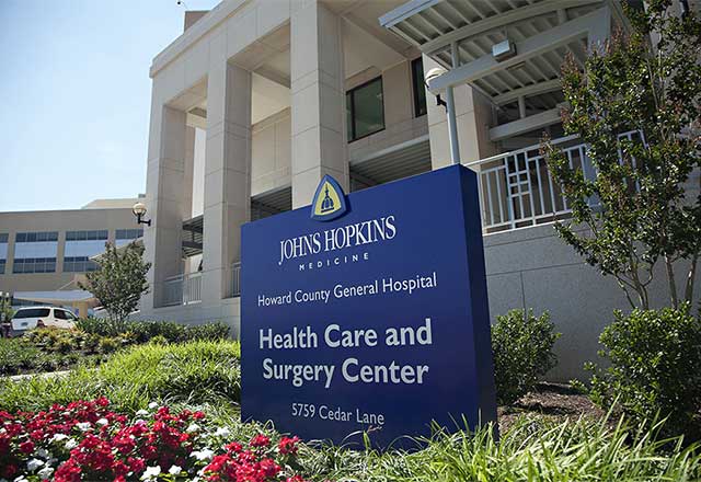 Johns Hopkins Medicine Howard County General Hospital Health Care and Surgery Center sign in front of entrance.