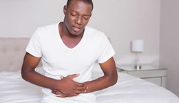 Man clutching his stomach in pain