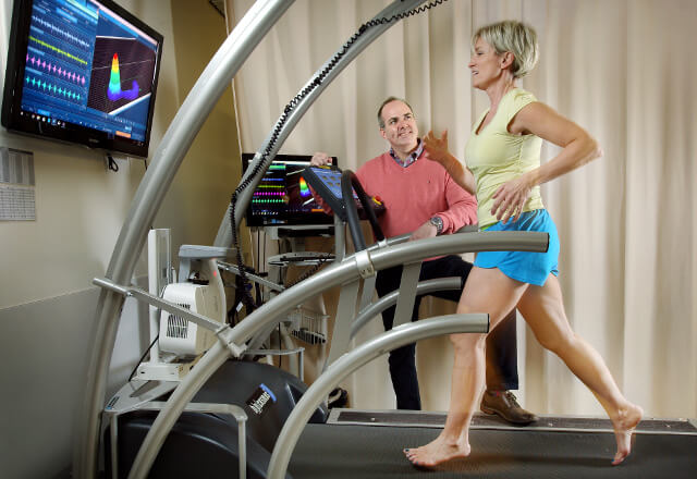 Physical therapist working with patient on treadmill.